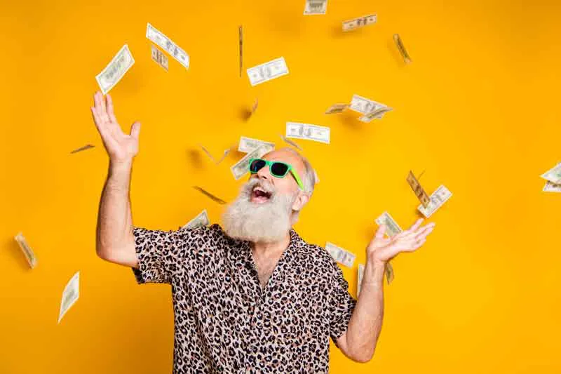 A happy man with money falling around him, representing the excitement of checking and receiving a tax refund status.