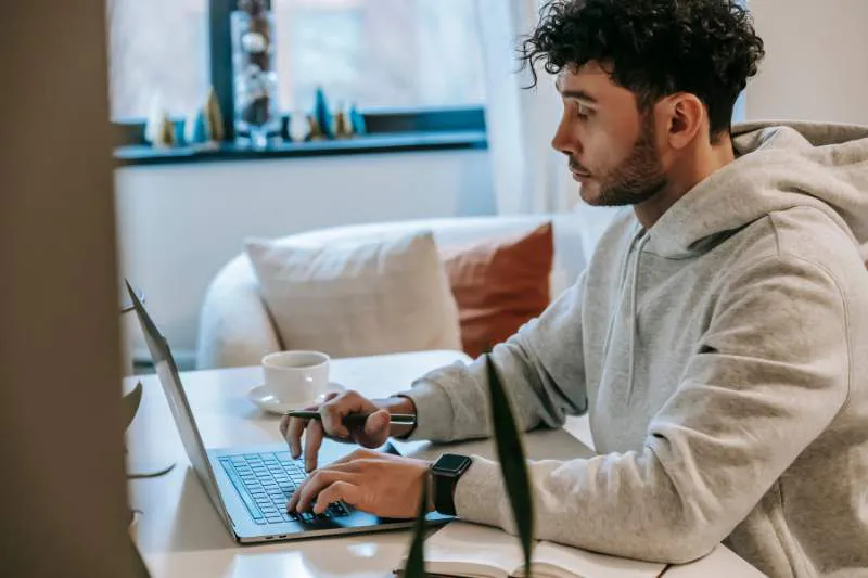 Man using a laptop to learn about FICA taxes and how they impact wages.