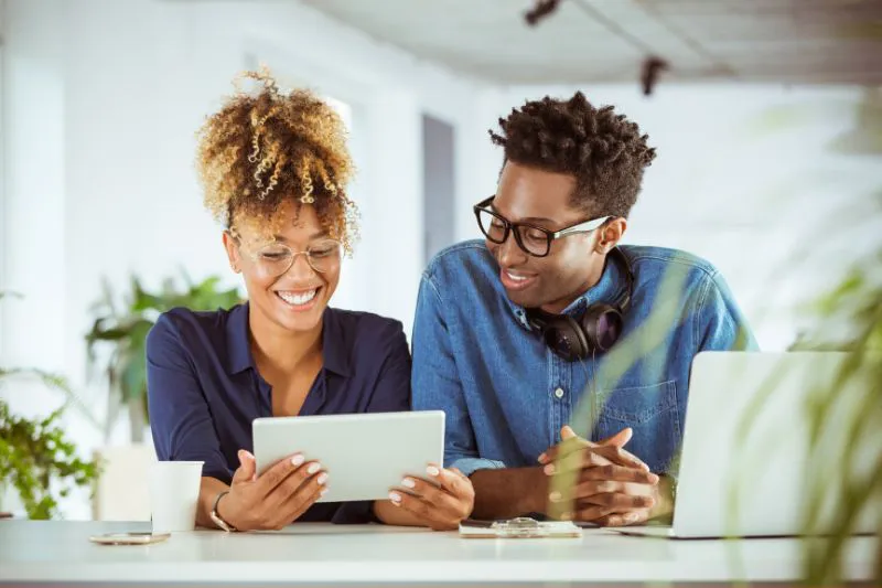 Man and woman reviewing their tax return status on a tablet, looking at the message 'Your Return Is Being Processed'.