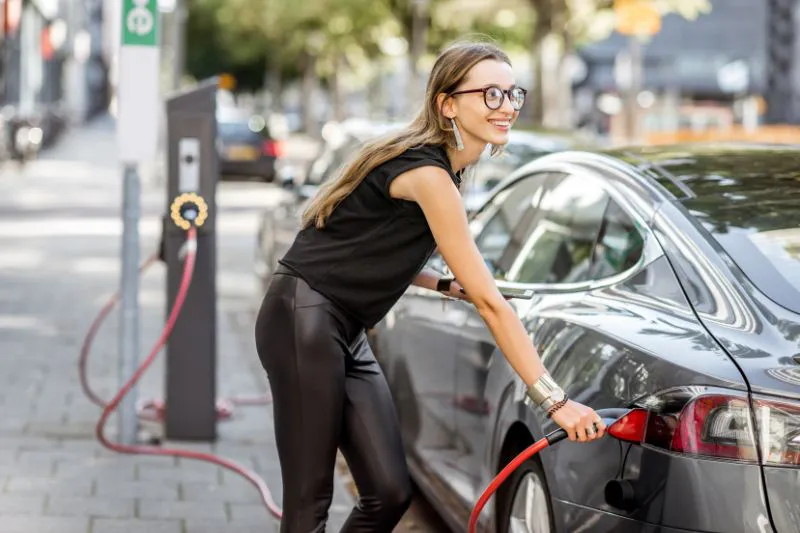 Girl charging electric vehicle