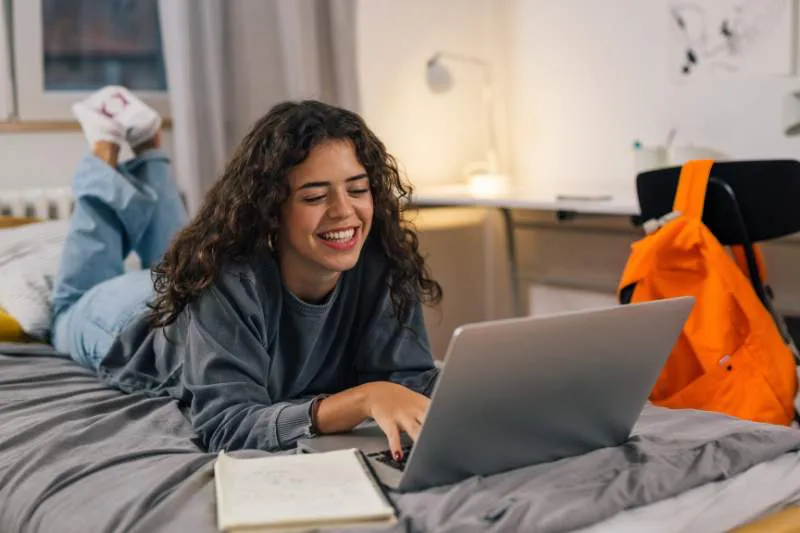 College student looking at laptop researching if scholarships are taxable income